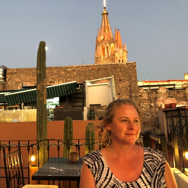 Lady sitting in front of a church on a balcony during sunset