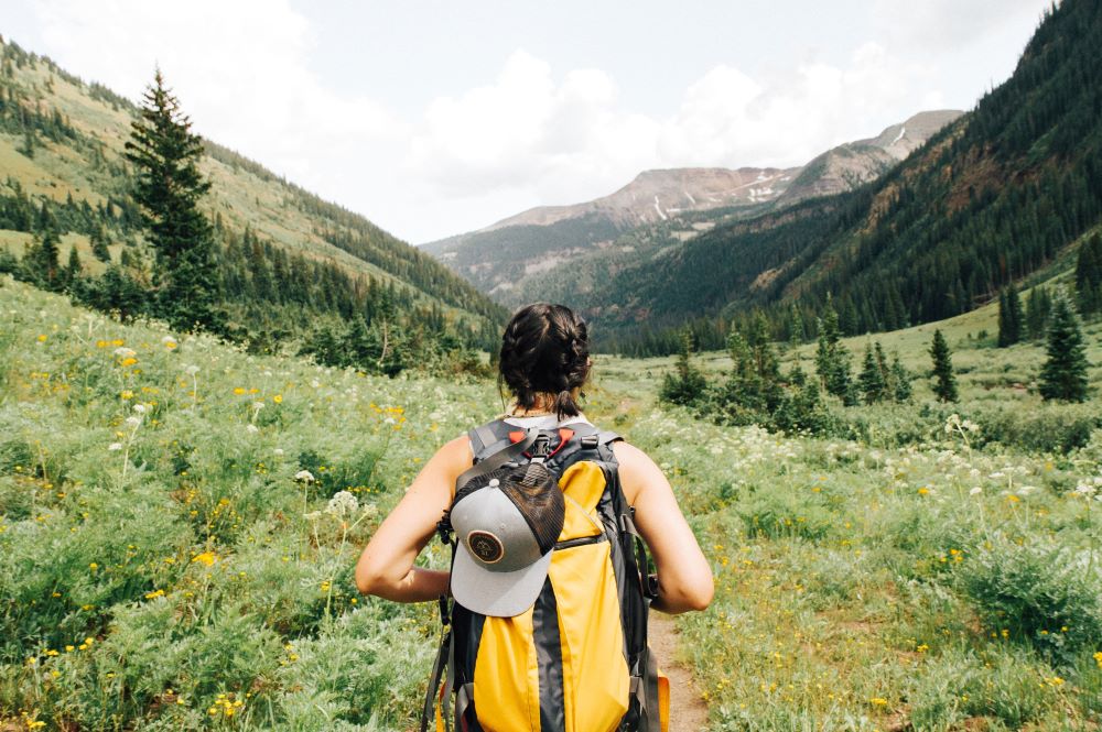 Woman hiking through green hills