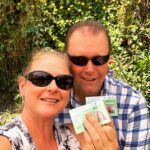 A man and a woman holding green cards