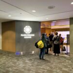 people standing in line at an airport lounge