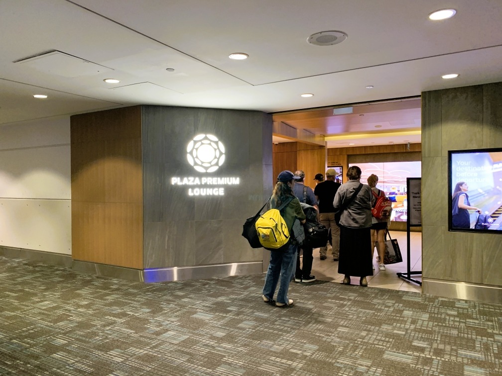 people standing in line at an airport lounge