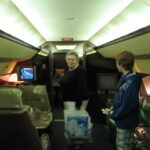 lady and young man standing inside an airplane