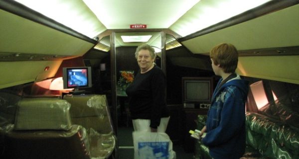 lady and young man standing inside an airplane