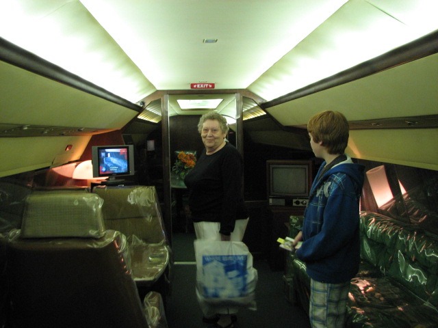 lady and young man standing inside an airplane