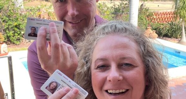 Permanent residency in Mexico. Two people holding their residency cards.