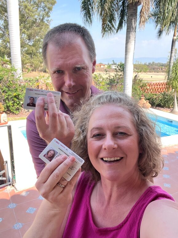 Permanent residency in Mexico. Two people holding their residency cards.